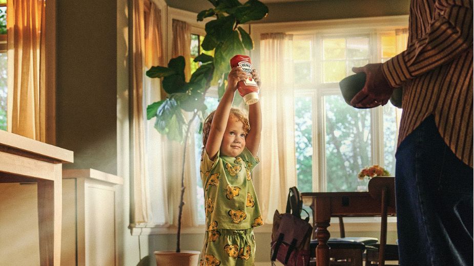 Nino con pijama de El Rey Leon levantando un bote de ketchup Heinz con los brazos en alto, recreando la escena de Simba, en la campana Together at Last de Kraft Heinz y Disney