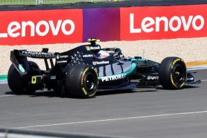 Monoplaza Mercedes de Formula 1 de Kimi Antonelli en pista con vallas publicitarias de patrocinadores al fondo