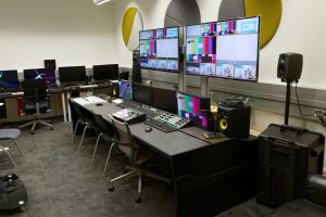 Sala de postproduccion vacia del YouTube Space de Paris, con puestos de edicion y monitores mostrando cartas de ajuste
