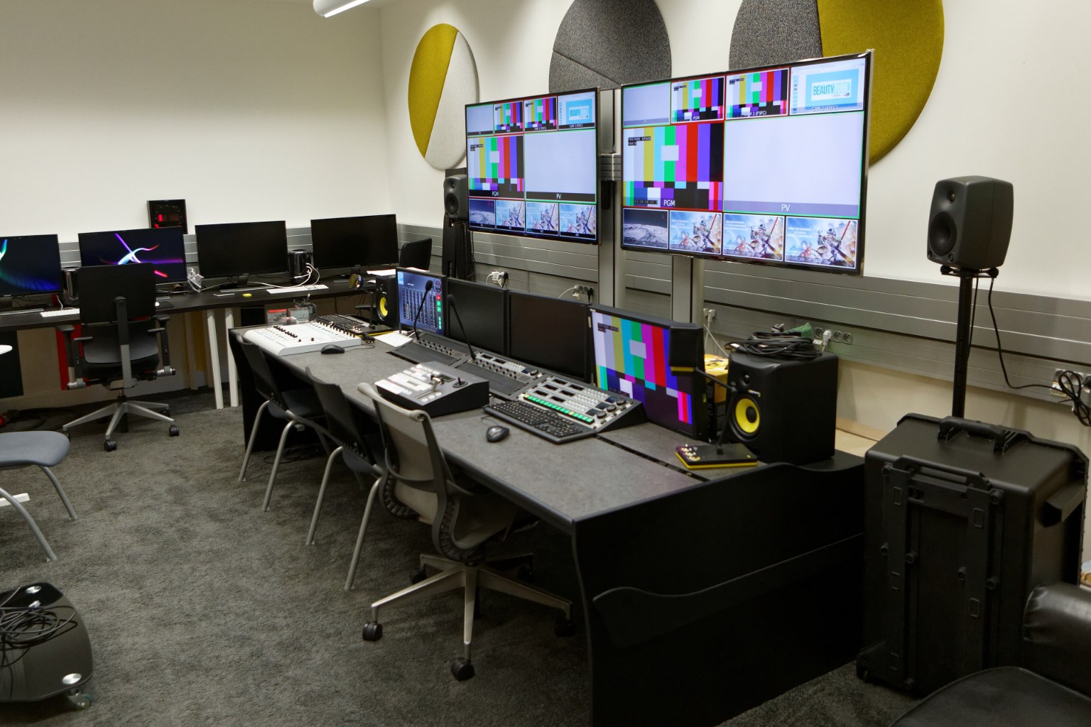 Sala de postproduccion vacia del YouTube Space de Paris, con puestos de edicion y monitores mostrando cartas de ajuste