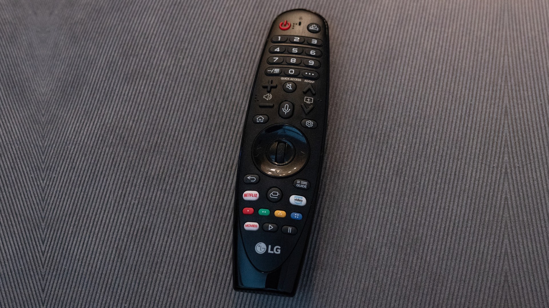 Mando Magic Remote de una televisión LG OLED C9 con el botón de micrófono y los botones patrocinados de Netflix y Prime Video