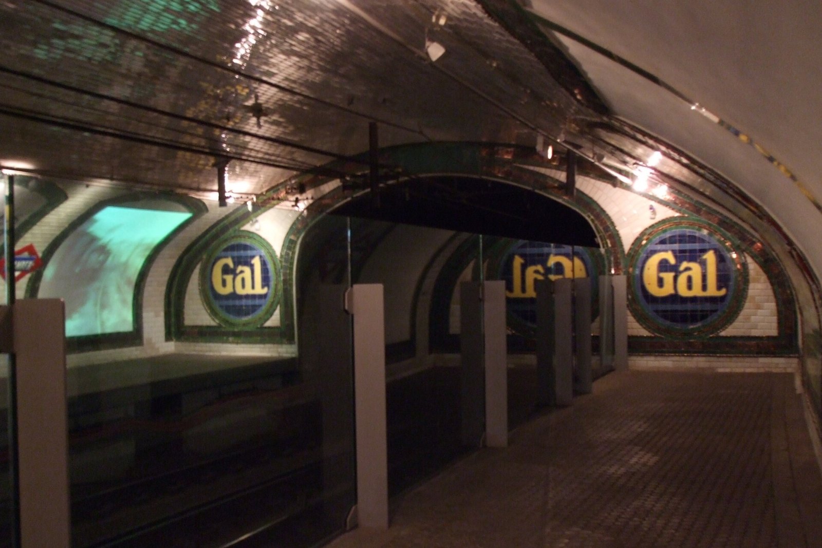 Andén curvo de la estación de Chamberí con los anuncios circulares de azulejo de la marca Gal